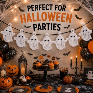 Peut inclure: Une guirlande de fantômes crochetés en blanc composée de sept silhouettes avec des yeux noirs, suspendue sur un cordon noir. La guirlande est présentée au-dessus d'une table avec des citrouilles, des cupcakes, une lanterne et des bougies.