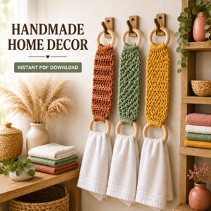Könnte beinhalten: Drei Makramee-Handtuchhalter in Rost, Salbeigrün und Senfgelb, jeweils mit zwei hellen Holzringen und einem weißen Handtuch. Der Text lautet HANDMADE HOME DECOR und INSTANT PDF DOWNLOAD. Die Halter hängen an hölzernen Wandhaken.