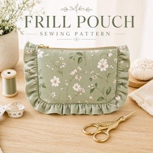 May include: A sage green fabric pouch featuring a white floral pattern and ruffled edges along the sides and bottom. The pouch has a gold-toned zipper closure. Text above the pouch reads "FRILL POUCH SEWING PATTERN" in dark green.