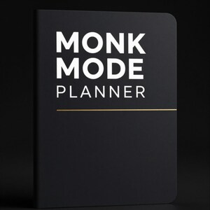 Peut inclure: Un agenda noir aux coins arrondis. La couverture affiche les mots "MONK MODE PLANNER" en blanc, avec une ligne horizontale dorée en dessous. L'agenda est posé sur un fond sombre.