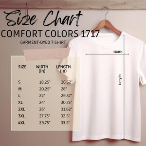 May include: A white Comfort Colors 1717 garment-dyed t-shirt on a wooden hanger. A size chart displays measurements in inches for width and length, from S to 4XL. The text "Size Chart" is at the top of the image.