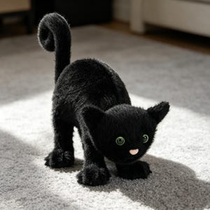 May include: A black plush cat toy with green eyes and a pink nose. The cat is in a playful pose, with its tail curled and its front paws extended. The cat's fur is soft and fluffy.
