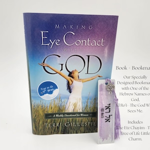May include: A book titled Making Eye Contact with God by Terri Gillespie featuring a cover image of a person in a white dress standing in a field with arms raised. Beside the book is a rectangular bookmark with Hebrew text, a lavender tassel, and a silver tree charm.