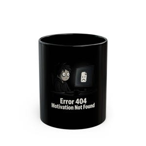 Könnte beinhalten: Ein schwarzer Keramikbecher mit einer Grafik einer Person vor einem Computer, auf dessen Bildschirm ein trauriges Dokument-Symbol zu sehen ist. Unter der Illustration steht in weißem Text: Error 404 Motivation Not Found. Das Design ist zentriert.