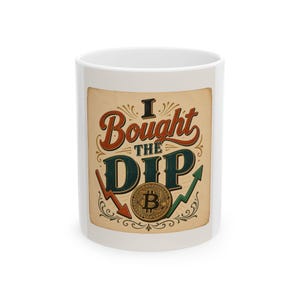 Może przedstawiać: Biały ceramiczny kubek z grafiką w stylu vintage z napisem I Bought The Dip czerwonymi i ciemnozielonymi literami. Projekt zawiera złoty symbol Bitcoina, czerwoną strzałkę skierowaną w dół oraz zieloną strzałkę skierowaną w górę.