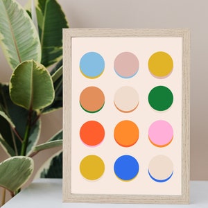 Pode incluir: Uma impress&atilde;o emoldurada com um design geom&eacute;trico de 12 c&iacute;rculos coloridos em tons de azul, rosa, amarelo, laranja, verde e marrom. Os c&iacute;rculos est&atilde;o dispostos em uma grade sobre um fundo creme.