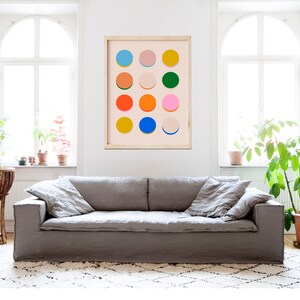 Pode incluir: Uma impress&atilde;o emoldurada com um design geom&eacute;trico de c&iacute;rculos coloridos sobre um fundo rosa claro. Os c&iacute;rculos s&atilde;o de v&aacute;rias cores, incluindo azul, verde, amarelo, laranja, rosa e vermelho.