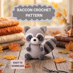 Puede incluir: Un mapache de ganchillo gris con una máscara en blanco y negro y una cola a rayas. La imagen incluye el texto "RACCON CROCHET PATTERN" y "EASY TO DOWNLOAD". Hojas de otoño decoran la escena.