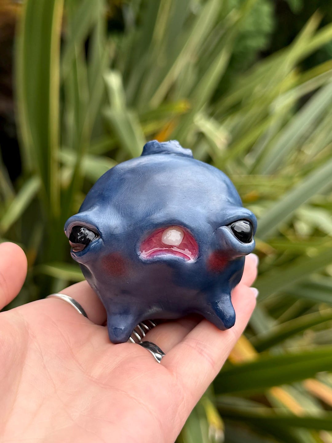 Cursed blueberry baby, a small blue three legged creature