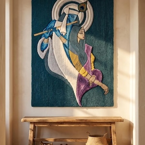 May include: A rectangular wall tapestry featuring a tufted design of two figures in blue, yellow, and purple tones. One figure plays a golden flute, while the other stands beside them. The artwork is set against a deep teal background with a circular white halo motif behind the figures' heads, incorporating a peacock feather detail.
