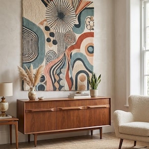 May include: A large rectangular wall hanging featuring a tufted texture with an abstract pattern of circles, waves, and lines in shades of cream, terracotta, blue, and charcoal. The design includes a central sunburst motif and organic shapes.