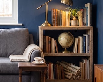 May include: A cozy living room scene featuring a wooden bookshelf filled with books, a globe, and a small potted plant. A brass desk lamp illuminates the top shelf. A gray sofa with a blanket and a small wooden side table with a teacup complete the scene.
