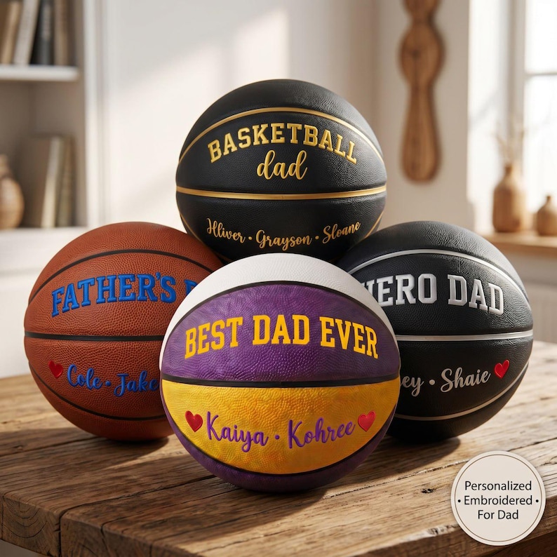 May include: Four basketballs with personalized text. One black ball says BASKETBALL dad with names. One brown ball says FATHER'S DAY with names and a red heart. One purple and yellow ball says BEST DAD EVER with names and red hearts. One black ball says HERO DAD.