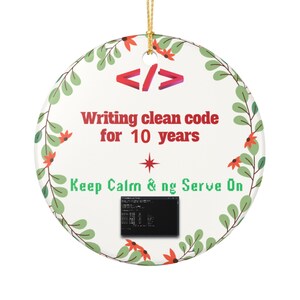May include: A round white ceramic ornament featuring a red code bracket icon, the text "Writing clean code for 10 years", a red star, the text "Keep Calm & ng Serve On" in green, and a small black computer terminal window graphic.