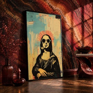May include: Framed art print featuring a pop art interpretation of the Mona Lisa wearing sunglasses and smoking a pipe. The artwork has a yellow, blue, and red color scheme with a black frame. The image is leaning against a textured wall.