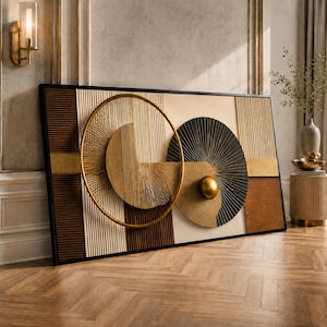 May include: Abstract wall art in a black frame. The artwork showcases geometric shapes in gold, brown, and beige. A large gold circular design is central, with a black fan-like shape and a gold sphere.