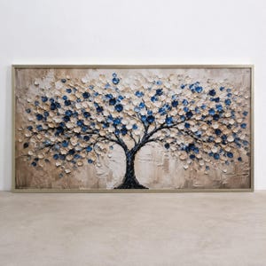 Puede incluir: Un cuadro rectangular con una pintura al óleo texturizada de un árbol con tronco y ramas oscuras. La copa está compuesta por pétalos gruesos de estilo impasto en tonos crema, beige y azul profundo sobre un fondo de colores neutros.