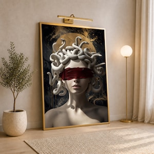 May include: A framed wall art print featuring a pale figure with snakes for hair, wearing a dark red blindfold over their eyes. The background is a dark, abstract composition with gold accents, set within a thin gold frame and illuminated by a light.