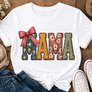 Könnte beinhalten: Ein weißes Kurzarm-T-Shirt mit dem Wort MAMA in großen Blockbuchstaben. Jeder Buchstabe hat ein einzigartiges Muster, darunter Blumenprints, Punkte und einfarbige Flächen. Eine große, strukturierte rote Schleife ist am ersten Buchstaben M befestigt.