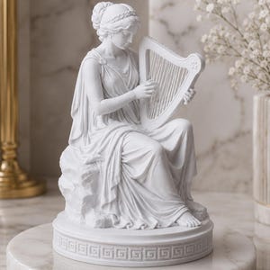 May include: A white matte statue of a seated figure playing a harp. The figure wears a draped garment and a headband. The statue rests on a circular base featuring a repeating Greek key pattern around the edge, with detailed folds in the fabric.