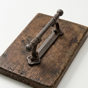 May include: A rectangular wooden sign with a distressed, brown finish. A wrought iron handle is attached with screws. The handle has a bar with decorative ball ends and a mounting plate.