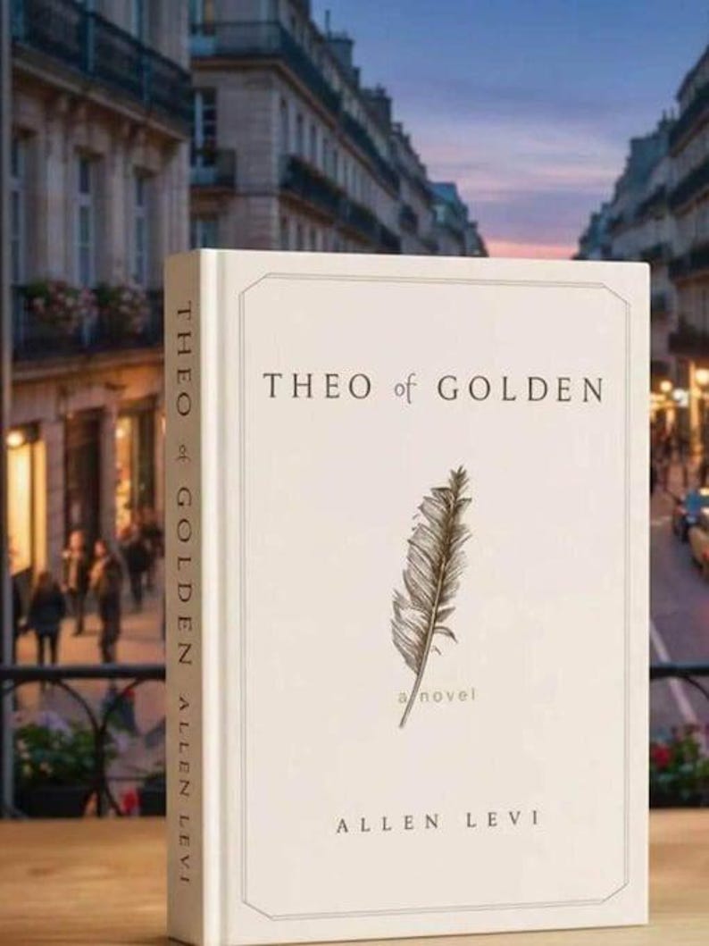 May include: A hardcover book titled "THEO of GOLDEN" by Allen Levi. The book has a cream-colored cover with a feather illustration and the words "a novel". The spine reads "THEO of GOLDEN ALLEN LEVI". The background shows a European street scene.