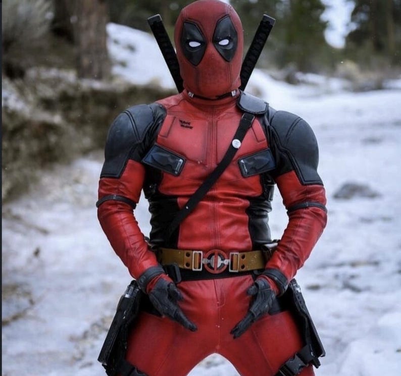 Puede incluir: Un disfraz de Deadpool rojo y negro con una m&aacute;scara, dos espadas en la espalda y un cintur&oacute;n de herramientas. El disfraz tiene una apariencia de cuero y se usa en un entorno nevado al aire libre.
