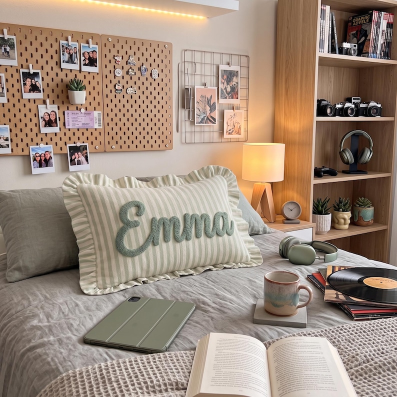 a cozy bedroom with a bed, a wooden bookshelf, and various personal items such as a lamp, a record player, and a laptop.