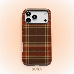 Puede incluir: Una funda para smartphone con un patr&oacute;n de cuadros en tonos marr&oacute;n, beige y naranja. La funda tiene un recorte rectangular para un sistema de triple c&aacute;mara y un flash. El texto KUKA case aparece impreso en letra peque&ntilde;a al pie.