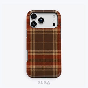 Puede incluir: Una funda para smartphone con un patr&oacute;n de cuadros en marr&oacute;n, beige y naranja oscuro. La funda tiene un recorte rectangular en la parte superior para un sistema de triple c&aacute;mara y flash. La palabra KUKA est&aacute; impresa en letras peque&ntilde;as de color gris claro en la parte inferior.