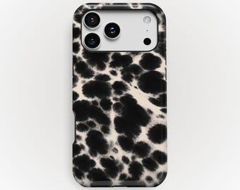 Puede incluir: Una funda para smartphone con un patrón abstracto de manchas de tinta o estampado animal en negro y crema. La funda tiene un recorte rectangular para un sistema de cámara de triple lente y un flash. La palabra KUKA case está impresa abajo.