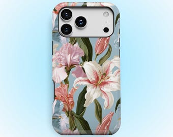 Puede incluir: Una funda para teléfono con fondo azul claro y un patrón floral de lirios e iris blancos y rosas, junto con hojas verdes. La funda tiene un recorte rectangular para la cámara en la parte superior y el texto KUKA case impreso en la base.