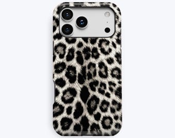 Puede incluir: Una funda rectangular para smartphone con un estampado de leopardo en blanco y negro. La funda tiene un recorte para un sistema de cámara de triple lente y un flash. La palabra KUKA está impresa en letras grises pequeñas en la parte inferior.