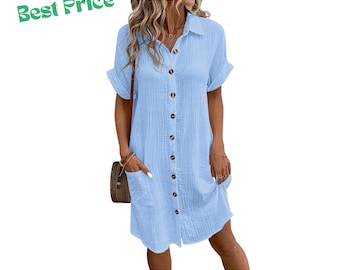 Pode incluir: Um vestido camiseiro azul claro com botões, gola, mangas curtas com punhos dobrados e dois bolsos frontais. O vestido apresenta um tecido texturizado e uma fila vertical de botões castanhos ao centro. O texto Best Price é visível.