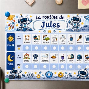 以下が含まれることがあります： La routine de Julesと書かれた長方形の磁気式ルーチンチャート。ロボット、ロケット、惑星などの宇宙をテーマにしたイラストが描かれています。朝と夜のタスクセクションには、日々の活動を示すアイコンと、進捗を記録するための空の円が配置されています。