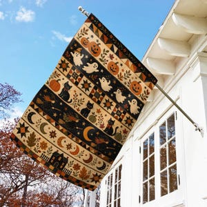 May include: A rectangular outdoor flag featuring a repeating pattern of Halloween motifs including orange pumpkins, white ghosts, black cats, flying witches, crescent moons, and autumn leaves, arranged in horizontal bands with geometric quilt-style borders.