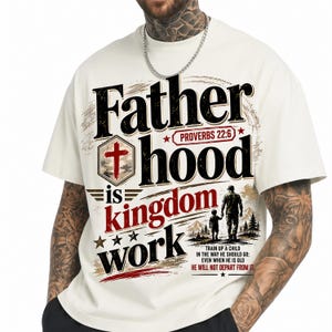 Peut inclure: T-shirt crème avec l'inscription "Fatherhood is Kingdom Work" en gras et vieilli. Le motif comprend une croix, des étoiles et un graphisme d'un père et d'un enfant marchant. Le texte "Proverbes 22:6" est également présent.