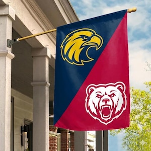 May include: A vertical house flag divided diagonally into a dark blue section and a red section. The blue section features a yellow eagle head graphic, while the red section displays a white bear head graphic with an open mouth and visible teeth.