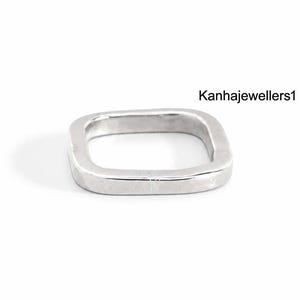 May include: A silver-toned square-shaped ring with a smooth, polished finish. The band features rounded corners and a consistent width throughout its design. The text Kanhajewellers1 is visible in the upper right corner of the image.