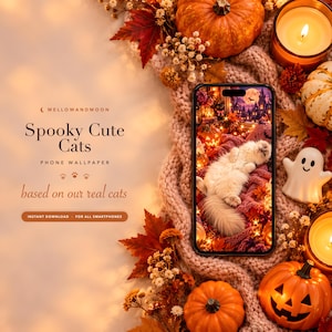 May include: A smartphone displaying a Spooky Cute Cats phone wallpaper, surrounded by autumn decor including pumpkins, a ghost figurine, candles, and dried flowers. The screen shows a white cat on a blanket with a spooky castle background.