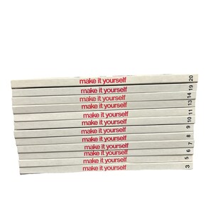 May include: A stack of eleven off-white books with red text on the spines that reads "make it yourself." Each spine is numbered on the right side, including the numbers 3, 5, 6, 7, 8, 9, 10, 11, 13, 14, 19, and 20, arranged in a vertical column.