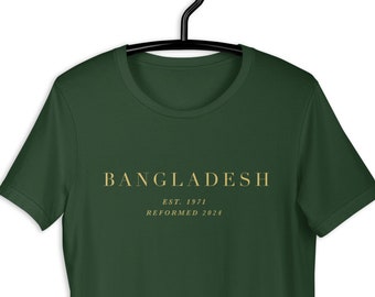 以下が含まれることがあります： ゴールドの文字で「BANGLADESH EST. 1971 REFORMED 2024」と書かれた濃い緑色のTシャツです。