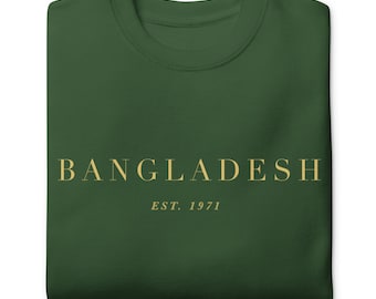 以下が含まれることがあります： ゴールドの文字で「BANGLADESH EST. 1971」と書かれた濃い緑色のTシャツです。