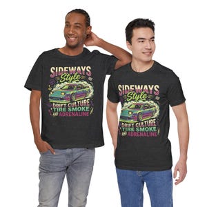 May include: Two people wearing dark gray t-shirts with a colorful graphic. The graphic features a car with the text "SIDEWAYS Style", "DRIFT CULTURE", "TIRE SMOKE", and "ADRENALINE". The car is surrounded by smoke.