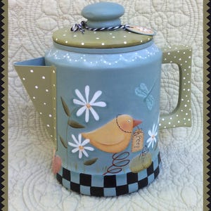 Puede incluir: Una cafetera de metal pintada de azul y verde con un diseño de lunares blancos. La cafetera presenta un pájaro amarillo con una etiqueta que dice "Peep!" y margaritas blancas.