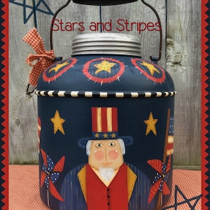 May include: A blue painted metal jar with a red, white, and blue Uncle Sam illustration, stars, and pinwheels. The jar has a black handle and a silver lid. The text "Stars and Stripes" is written on the jar.