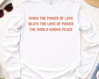 Camiseta de manga comprida com frase sobre a paz: Amor acima do poder - Camiseta unissex