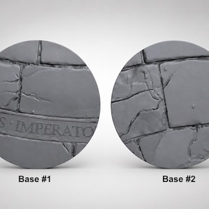 Puede incluir: Dos bases circulares grises con textura de piedra. La base n.º 1 tiene el texto "NUS IMPERATOR" y una superficie agrietada. La base n.º 2 tiene una textura de piedra similar. Ambas están sobre un fondo blanco.
