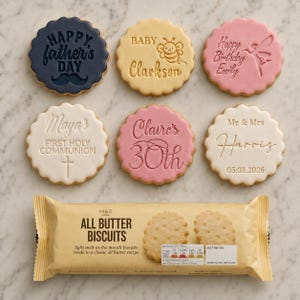 May include: A selection of iced biscuits with messages like "Happy Father's Day," "Baby Clarkson," and "Happy Birthday Emily." A packet of "All Butter Biscuits" is also visible. The biscuits are round with a scalloped edge.