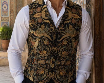 Puede incluir: Un chaleco sin mangas con base negra y un intrincado patrón floral y de volutas multicolor en tonos oro, bronce y azul apagado. El chaleco tiene cuello en V, cierre frontal con botones y se lleva sobre una camisa blanca impecable.